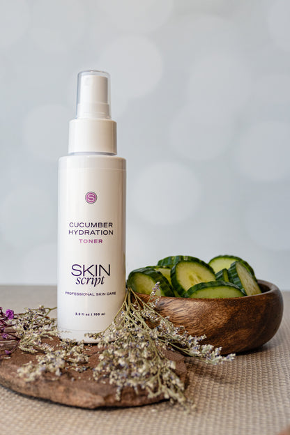 Skincare bottle labeled 'Cucumber Hydration Toner' by Skin Script on a neutral background with cucumbers.